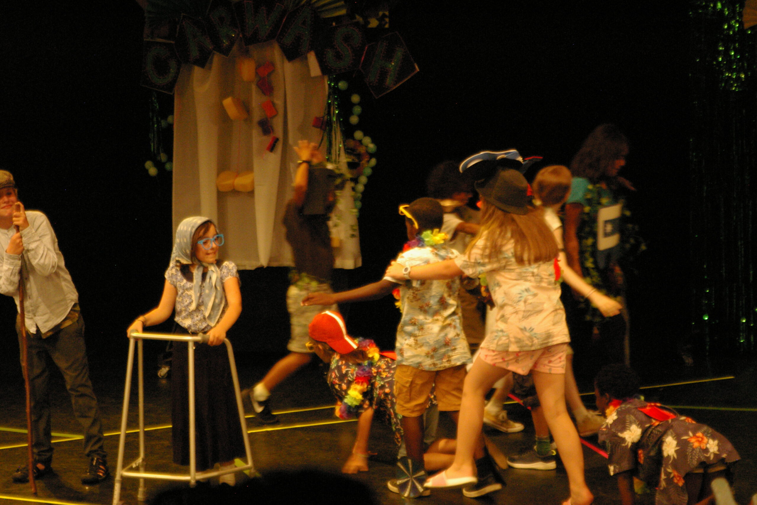 Group of children performing in a theatre with elaborate outfits