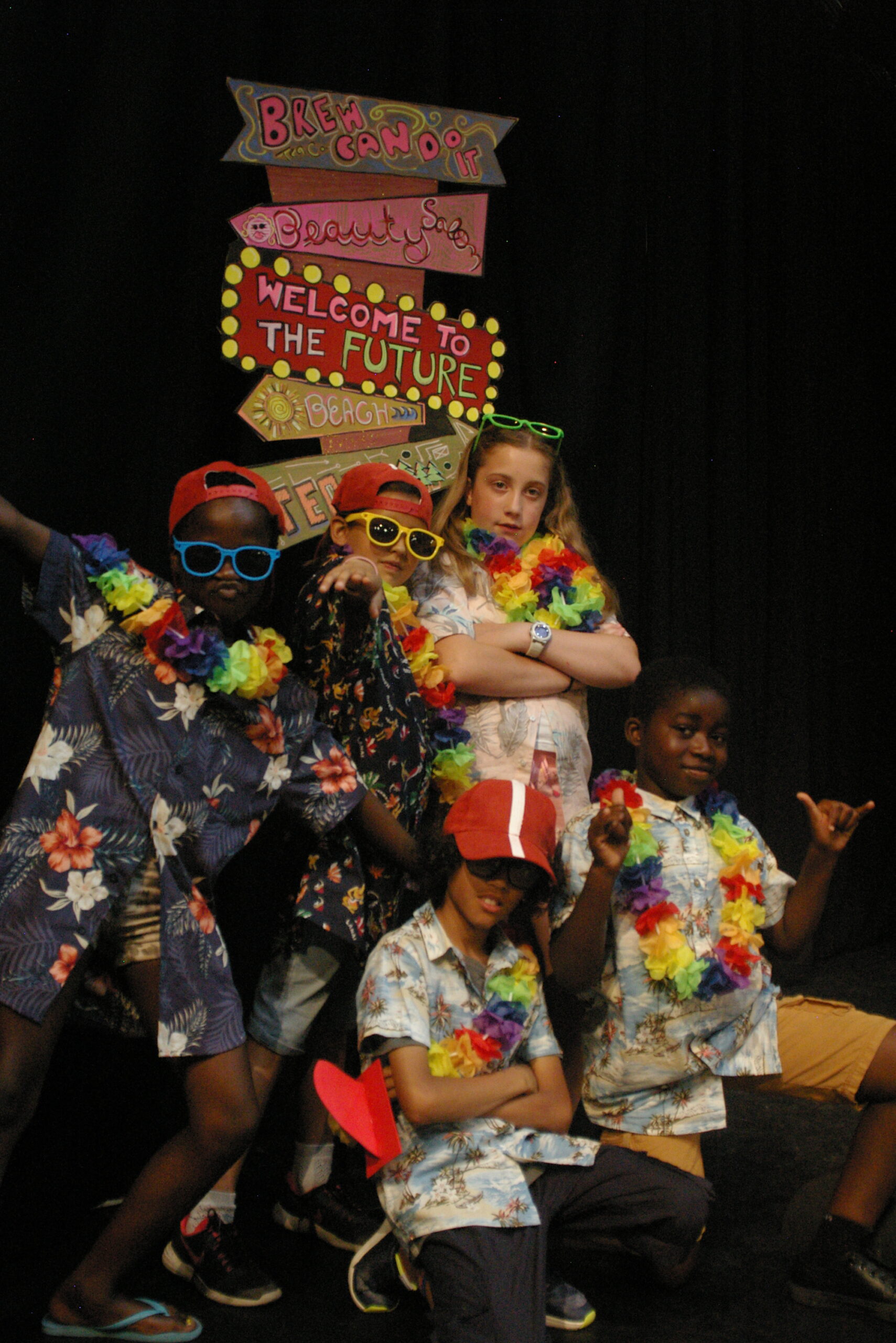 Group of children performing in a theatre with elaborate outfits